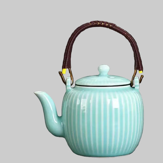 Turquoise ceramic teapot with a wicker handle